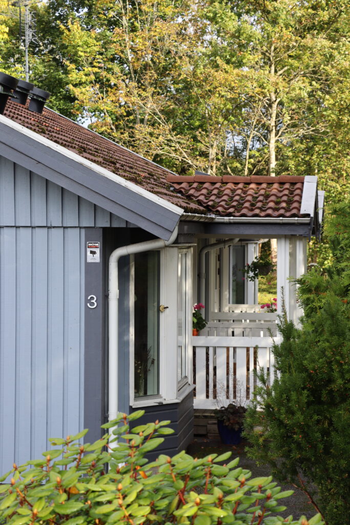 Flintavägen 3 fastighet från sidan, vit entre med staket.