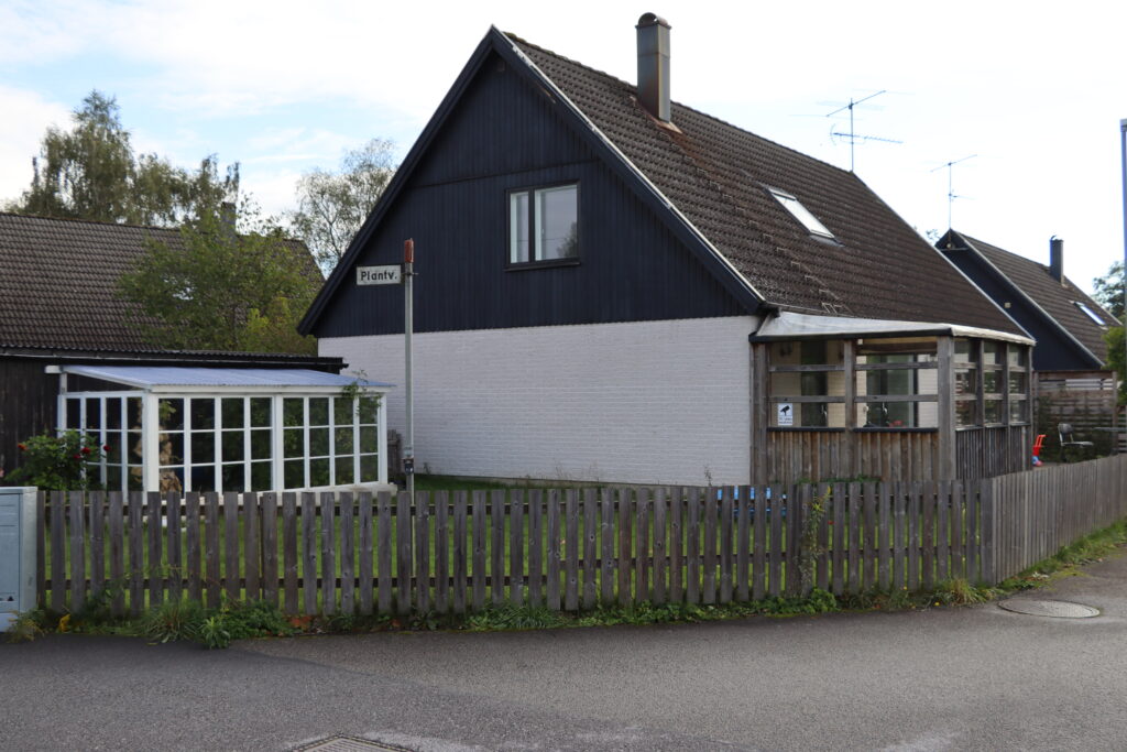 Fastighet på Grönalundsvägen i Höör, ljust tegel och svartmålat trä på ovanvåning med fönster.