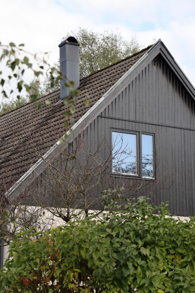 Fastighet på Grönalundsvägen i Höör, ovanvåning med svart husvägg och fönster.