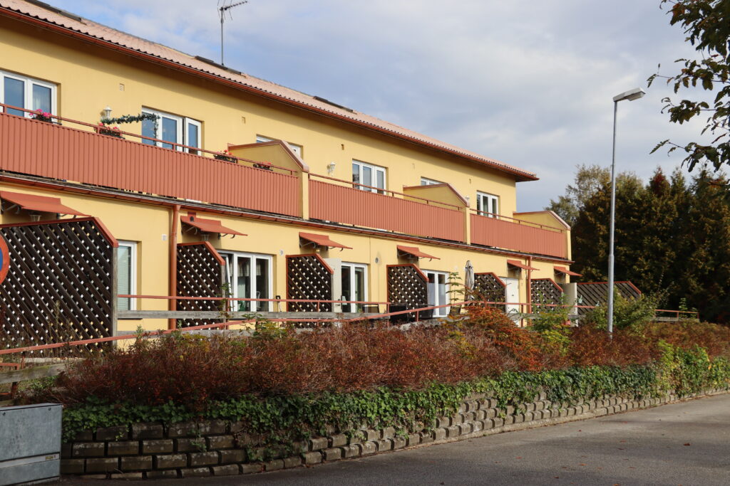 Möllebacken 3 i Höör, gul fastighet med två våningar separerade med vägg och röd balkong.