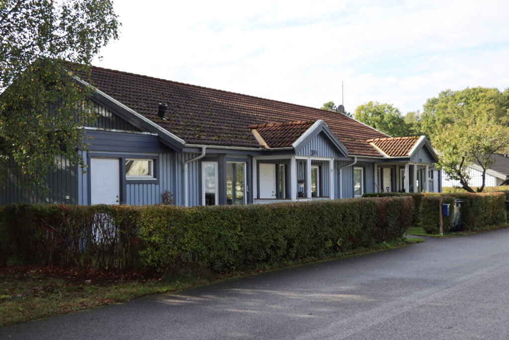 Kvarngatan, blå marklägenhet med häck och egen täppa.