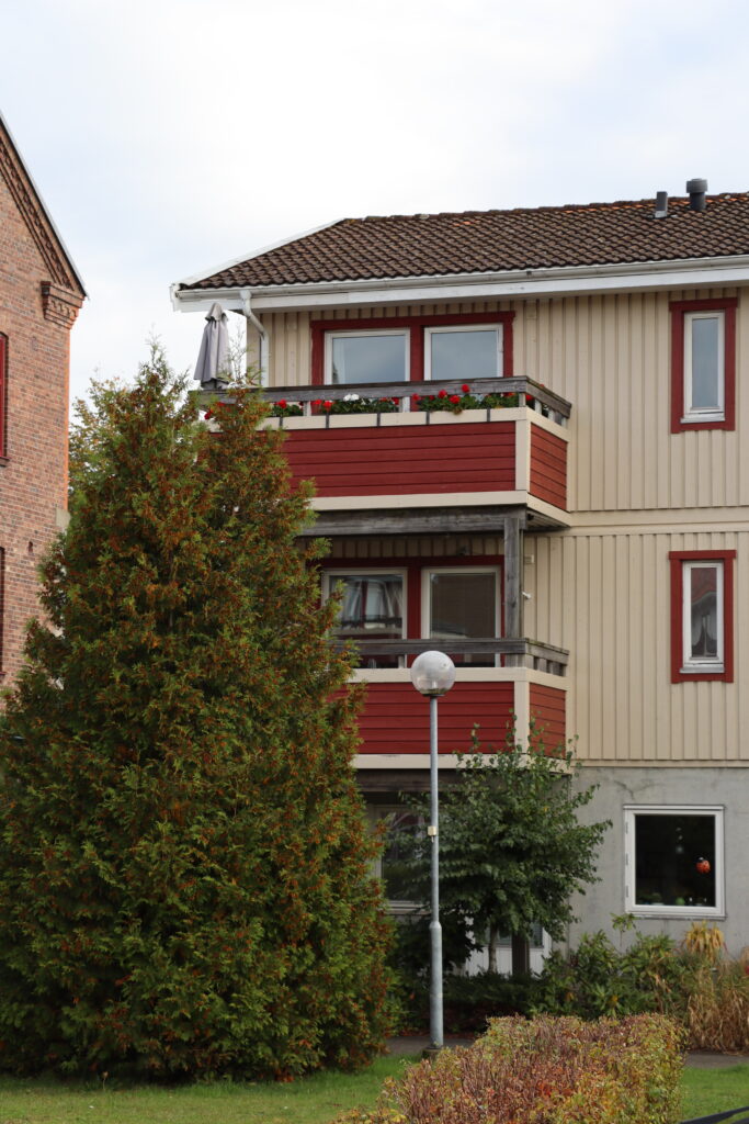 Fastighet i Höör, närbild på röda balkonger på två våningar.
