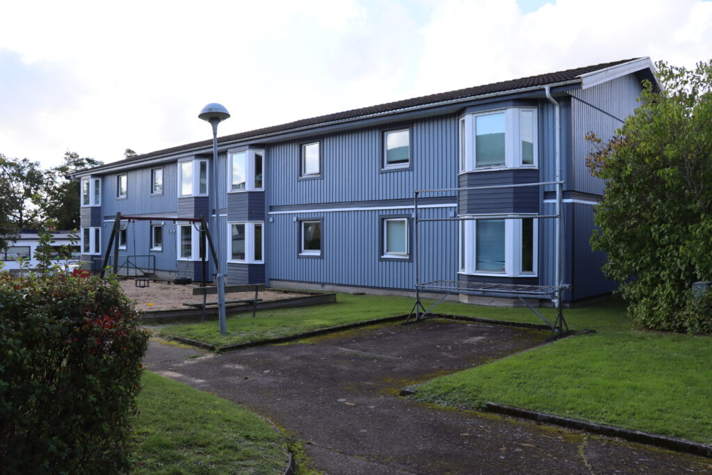 Baksida av fastighet på Tvärgatan i Höör, blått trä med vita fönsterkarmar.