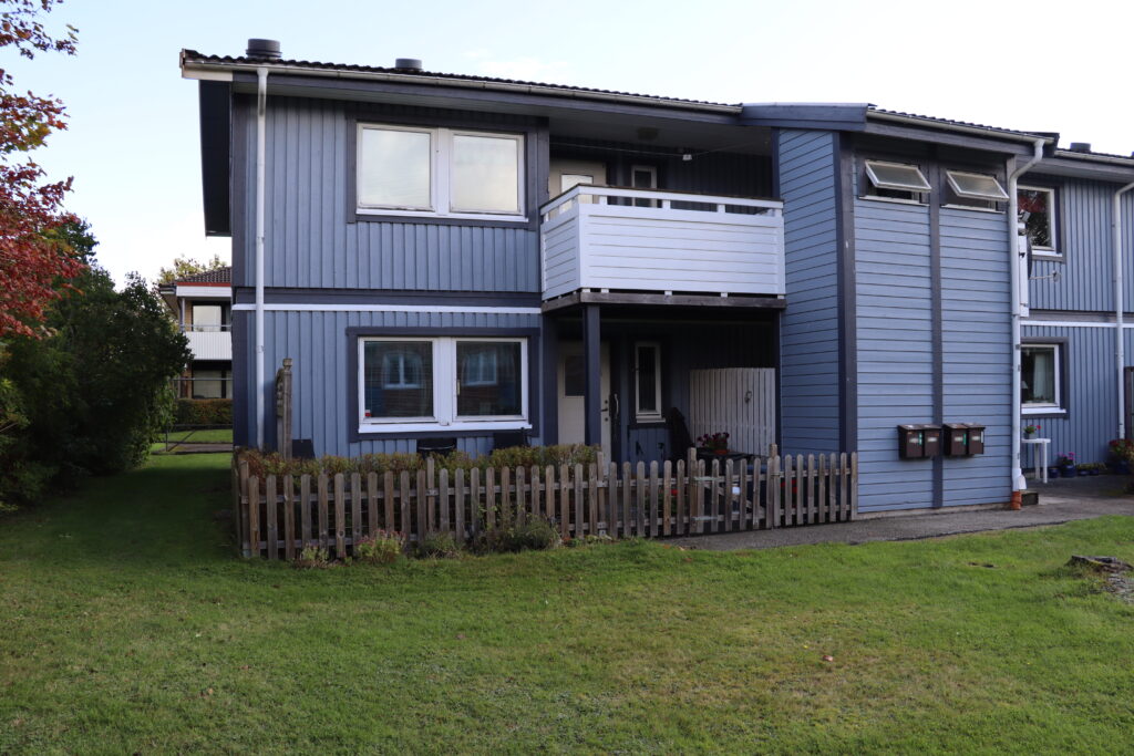 Uteplats på Tvärgatan med brunt staket.